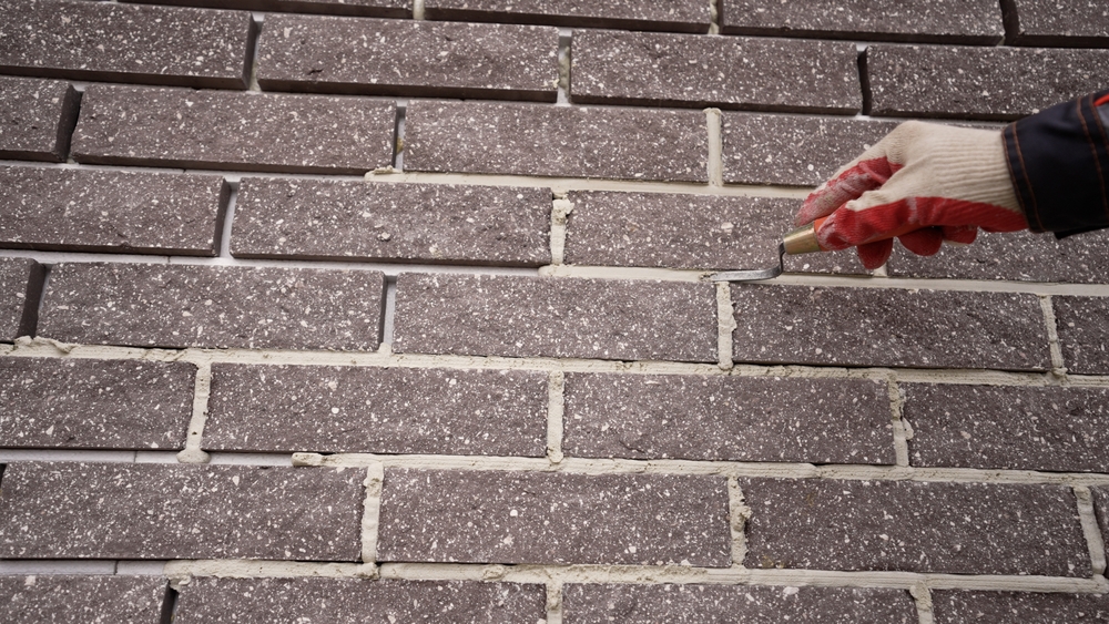 A,Worker,Applies,Mortar,To,A,Building's,Facade.,Grouting,Tiles