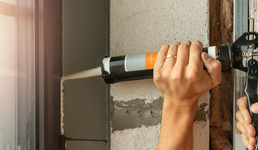 Using,Silicone,Adhesive,With,A,Glue,Gun,To,Repair,Windows.