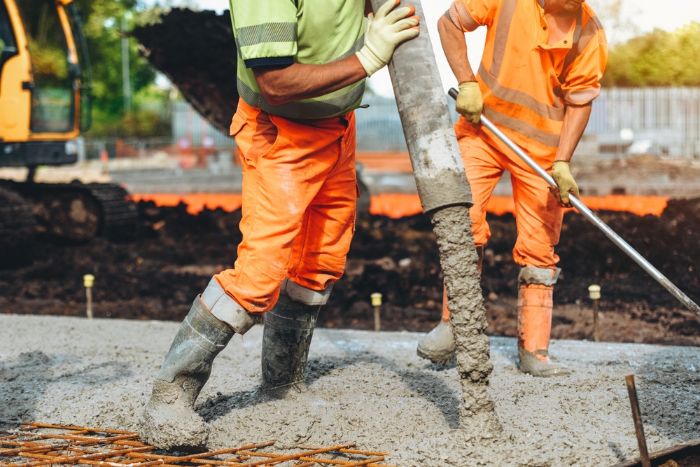 Construction,Workers,Pouring,Concrete,At,A,Building,Site,During,Daylight
