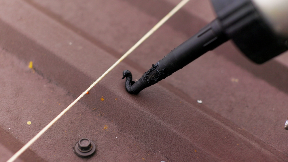 Close,Up,Of,Applying,Sealant,On,The,Roof.,Carpenter,Repairing