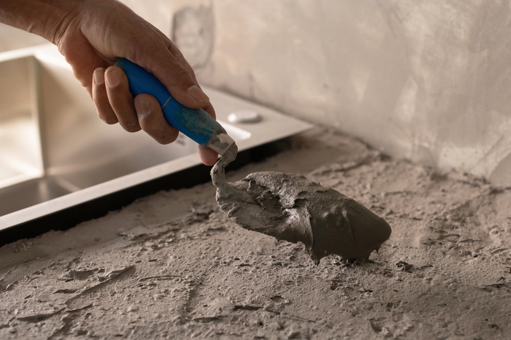 Professional,Hands,Holding,A,Trowel,To,Mix,Cement,For,Plastering,
