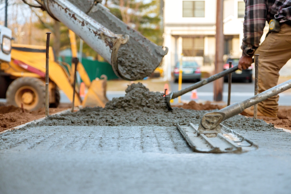 Workers,Pour,,Level,Fresh,Concrete,For,Sidewalk,Amidst,Construction,Activities