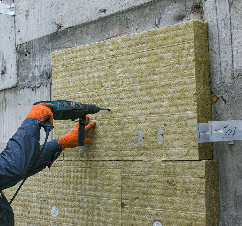 A,Man,Installs,A,Layer,Of,Thermal,Insulation,On,The