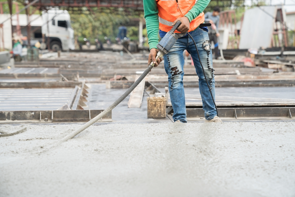 Construction,Technician,Uses,Concrete,Vibration,Generator,During,Leveling,Concrete,Floor.