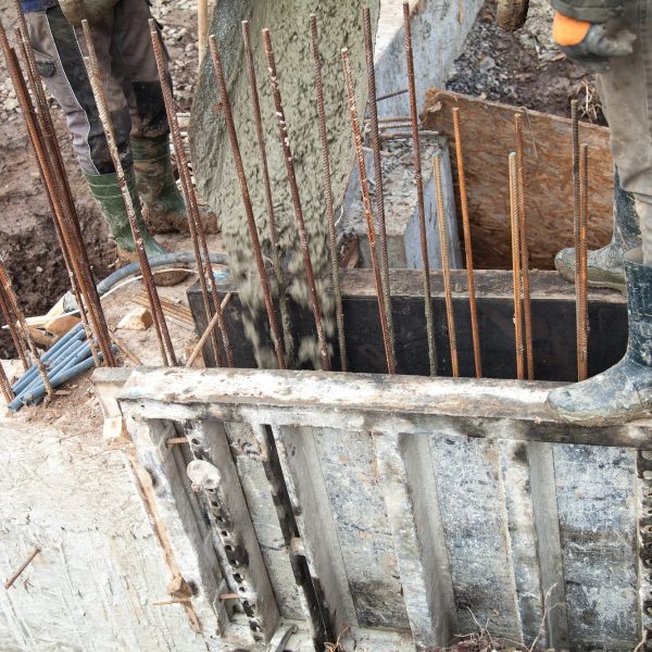 Pouring concrete into the construction of the house. Builders are pouring ready-mixed concrete