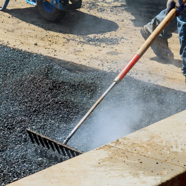 Workers on Asphalting paver during Road street repairing works